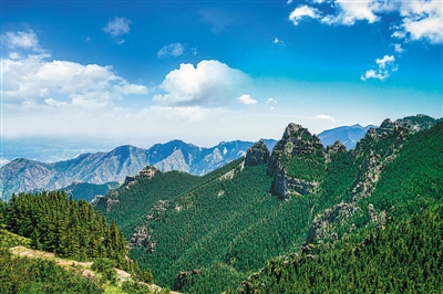 <p>朵朵白云下,群山屹立,巍峨壮美。</p>